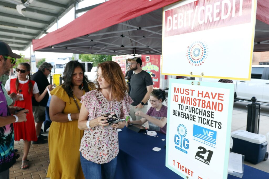 patrons purchasing drink tickets from volunteers at gig in the park concert